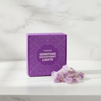 Amethyst crystal fairy lights on a marble table with a marble wall behind