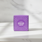 Amethyst crystal fairy lights on a marble table with a marble wall behind