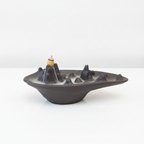 Mountain scape backflow incense burner with smoke running down the slopes
