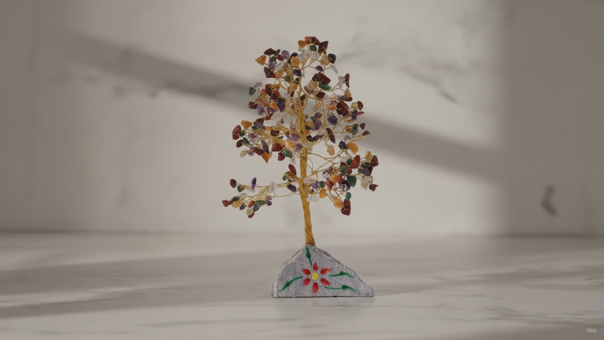 Large multi gemstone crystal tree on a marble table, sunlight moving across the wall