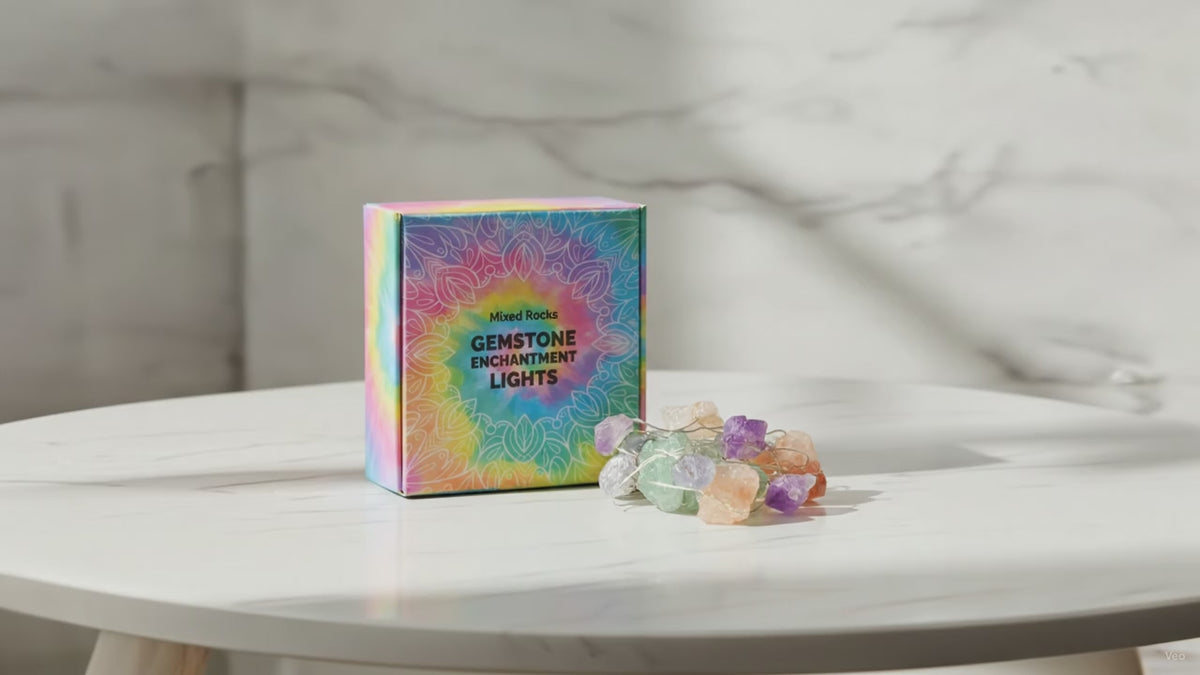 Mixed gemstone crystal fairy lights in their rainbow gift box on a marble table, sunlight moving across the wall