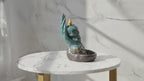 Video of the skull in hand backflow incense burner on a marble table, with the camera slowly moving in