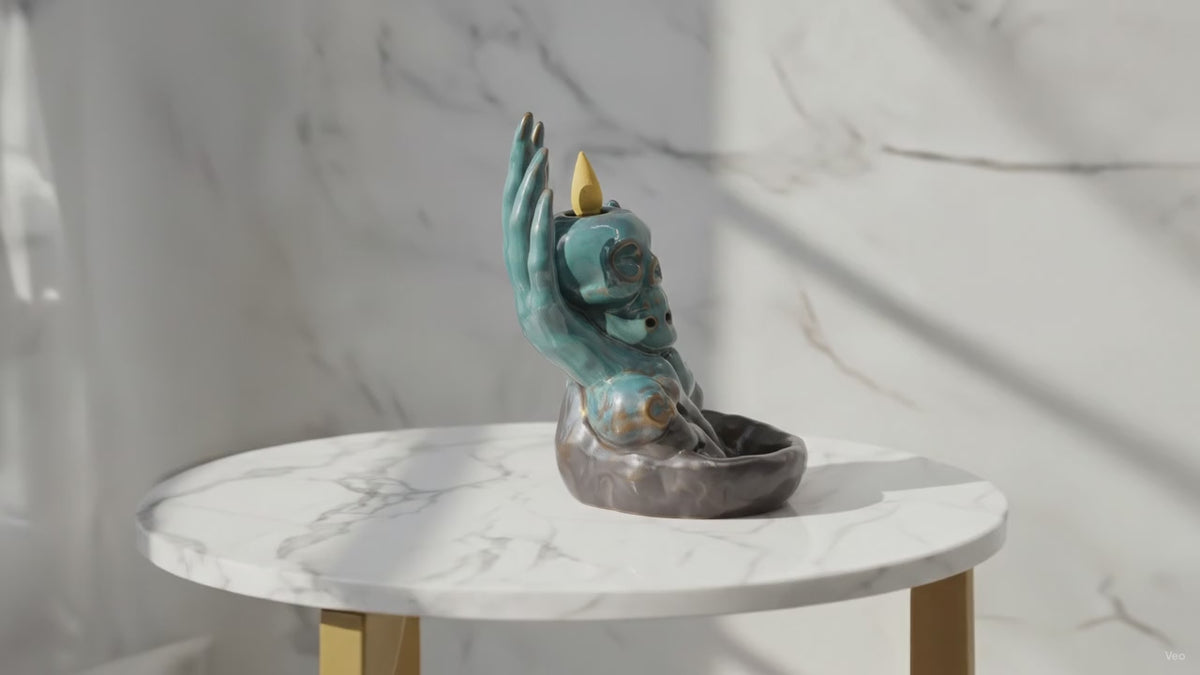 Video of the skull in hand backflow incense burner on a marble table, with the camera slowly moving in