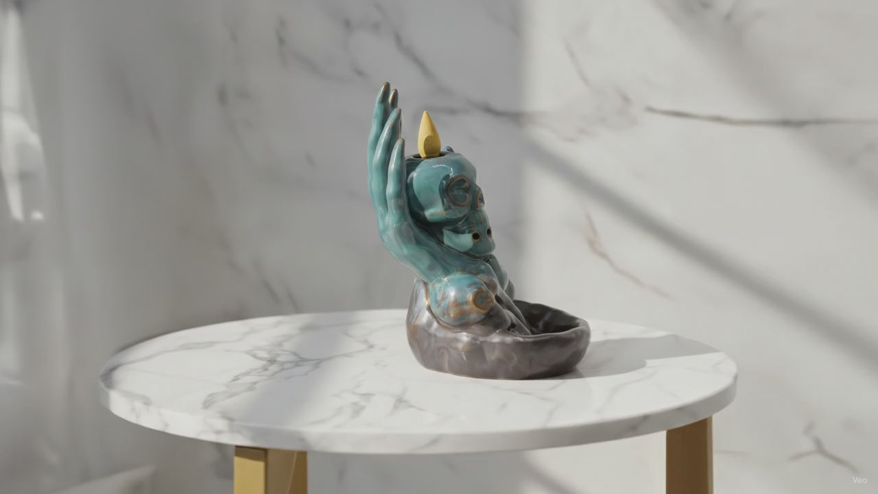 Video of the skull in hand backflow incense burner on a marble table, with the camera slowly moving in