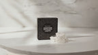 Clear quartz crystal fairy lights in their black gift box on a marble table, sunlight moving across the wall