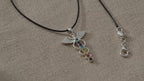 Angel wing chakra pendant necklace on black cord, on natural linen