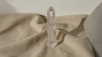 Clear quartz crystal obelisk point on linen, slow zoom in