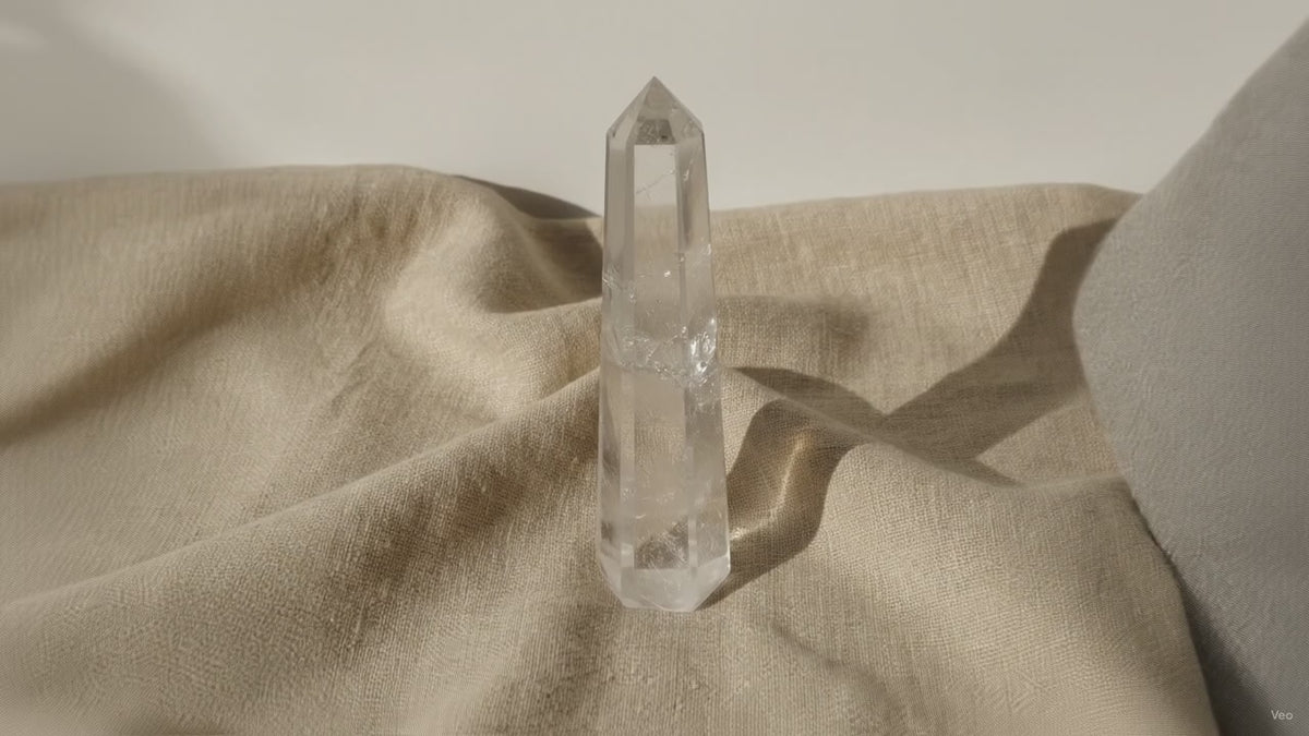 Clear quartz crystal obelisk point on linen, slow zoom in