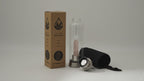 Rose quartz crystal water bottle with its box, lid and padded sleeve, soft light moving across the wall