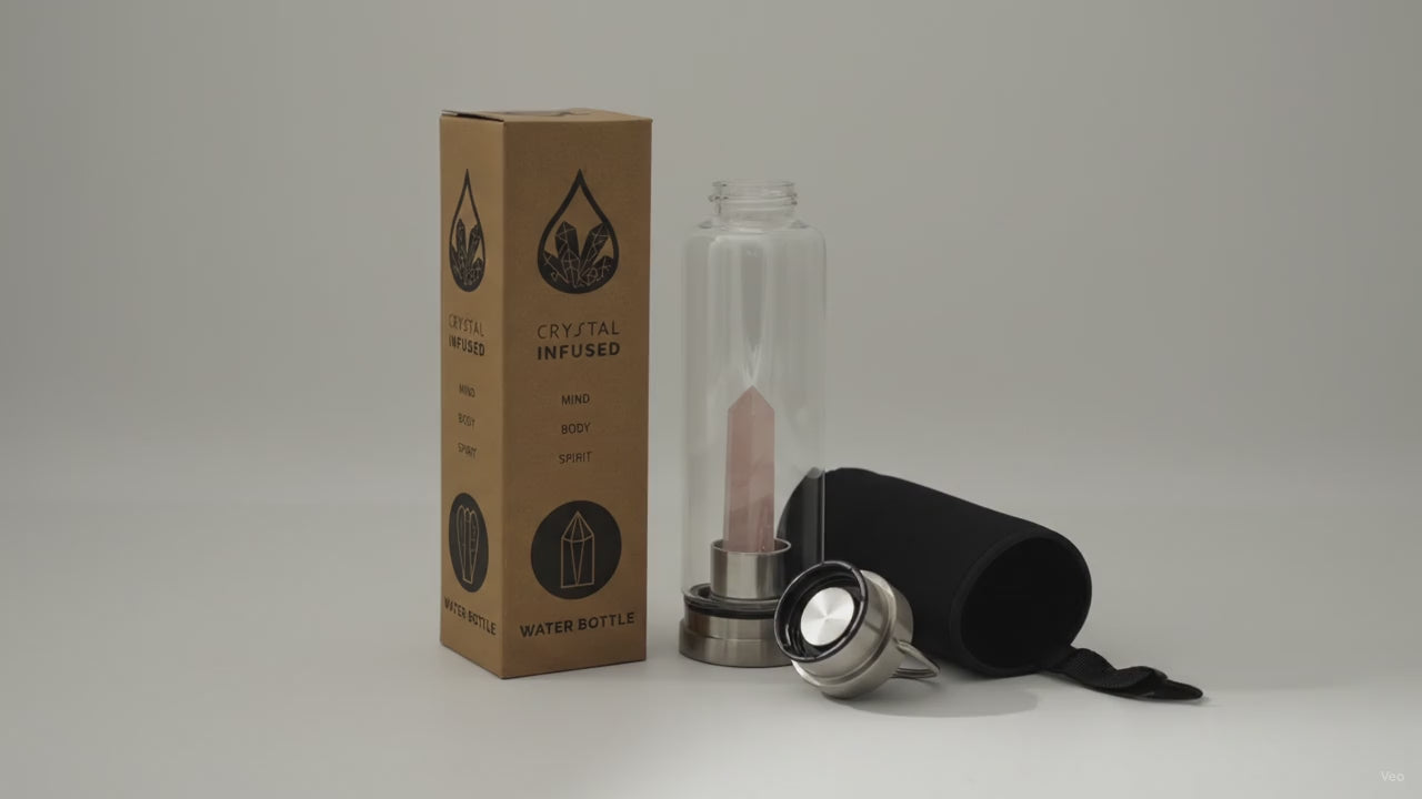 Rose quartz crystal water bottle with its box, lid and padded sleeve, soft light moving across the wall