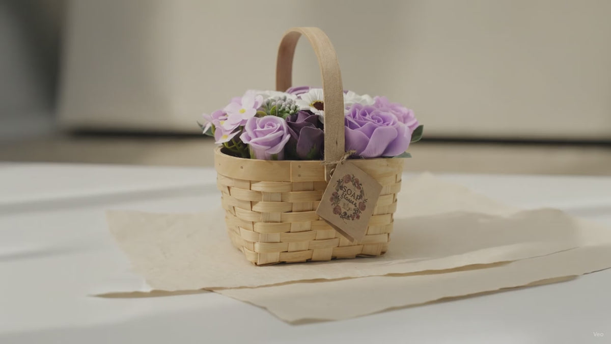 Lilac and purple soap roses in a woven wicker basket with a tag, on cotton-rag paper video