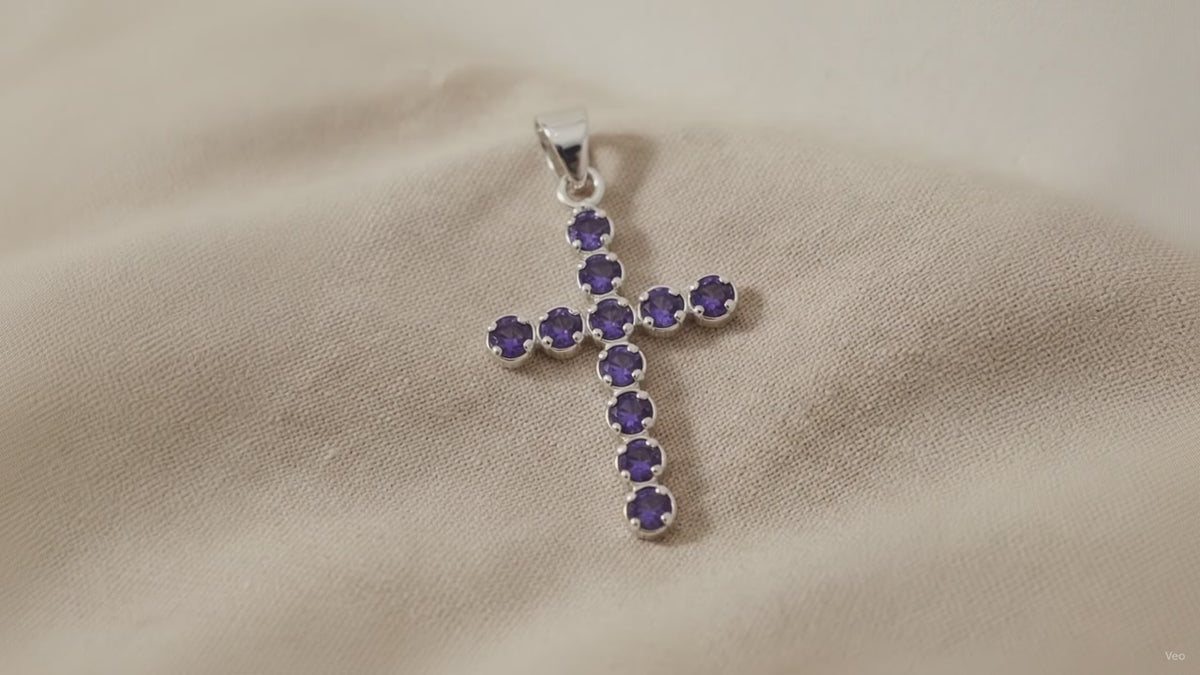 Silver-plated crucifix pendant set with deep purple stones, on linen video