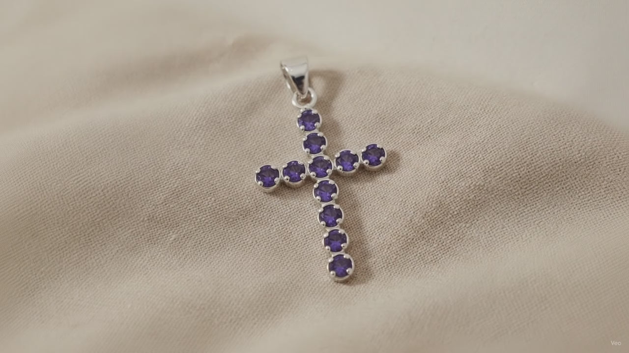 Silver-plated crucifix pendant set with deep purple stones, on linen video