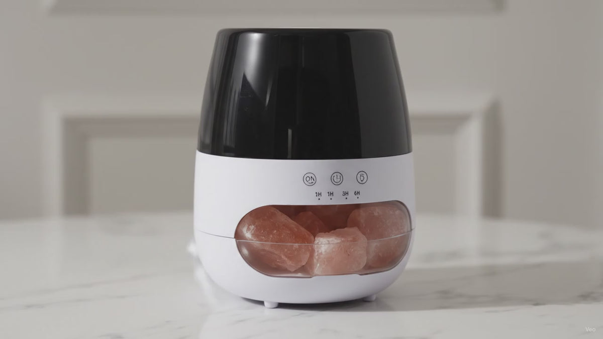 White salt stone flame effect aroma diffuser with glowing Himalayan salt chamber on marble, slow camera push-in