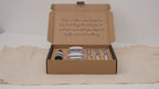 Kraft self-care kit box open flat, showing scrub tins, serum bottle and bath salt tubes video