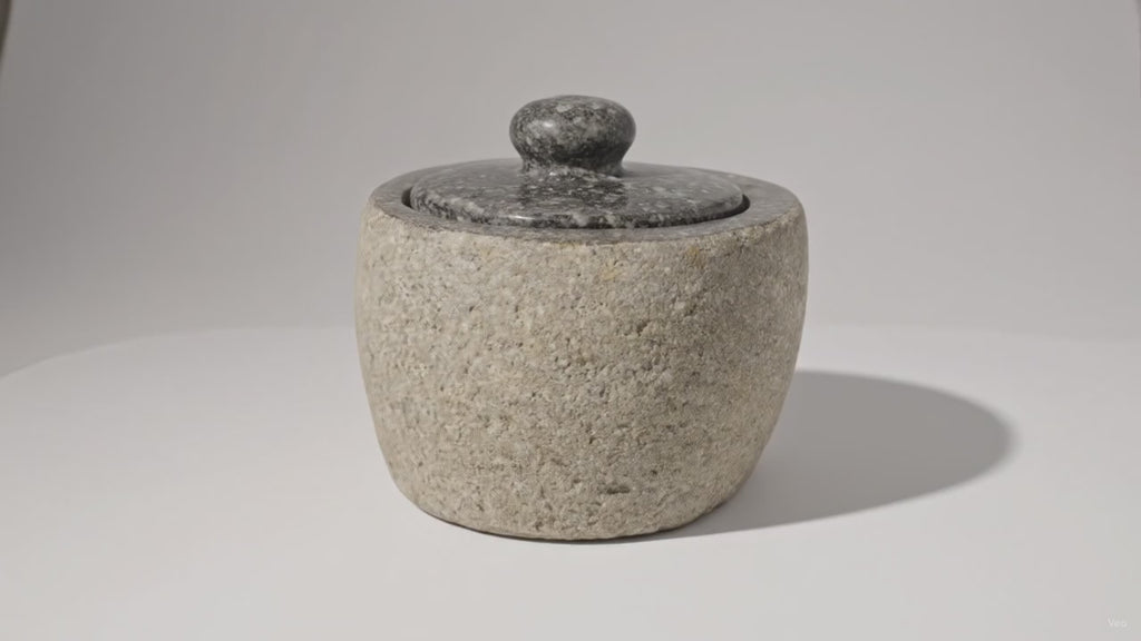 Video of the small river stone pot with its stone lid, the camera slowly moving in