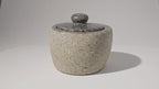 Video of the small river stone pot with its stone lid, the camera slowly moving in