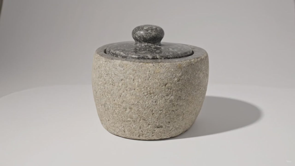 Video of the small river stone pot with its stone lid, the camera slowly moving in