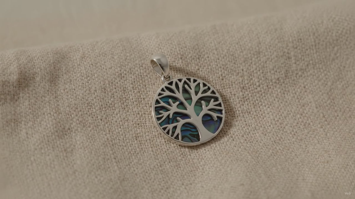 Silver Tree of Life pendant set over blue-green abalone shell - video