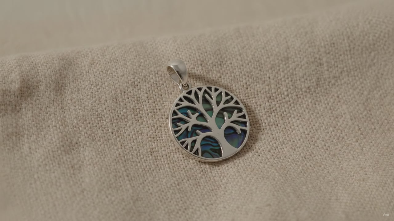 Silver Tree of Life pendant set over blue-green abalone shell - video