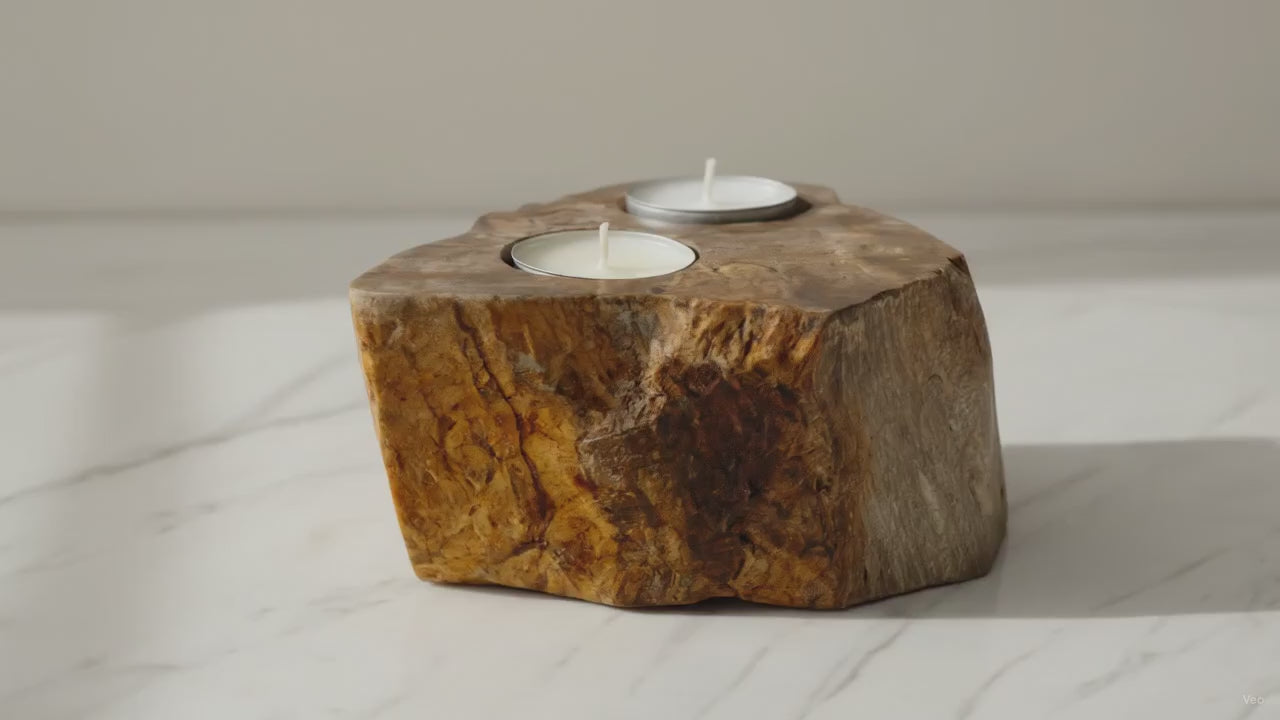 Double petrified wood candle holder with two tealights on a marble worktop, slow camera orbit