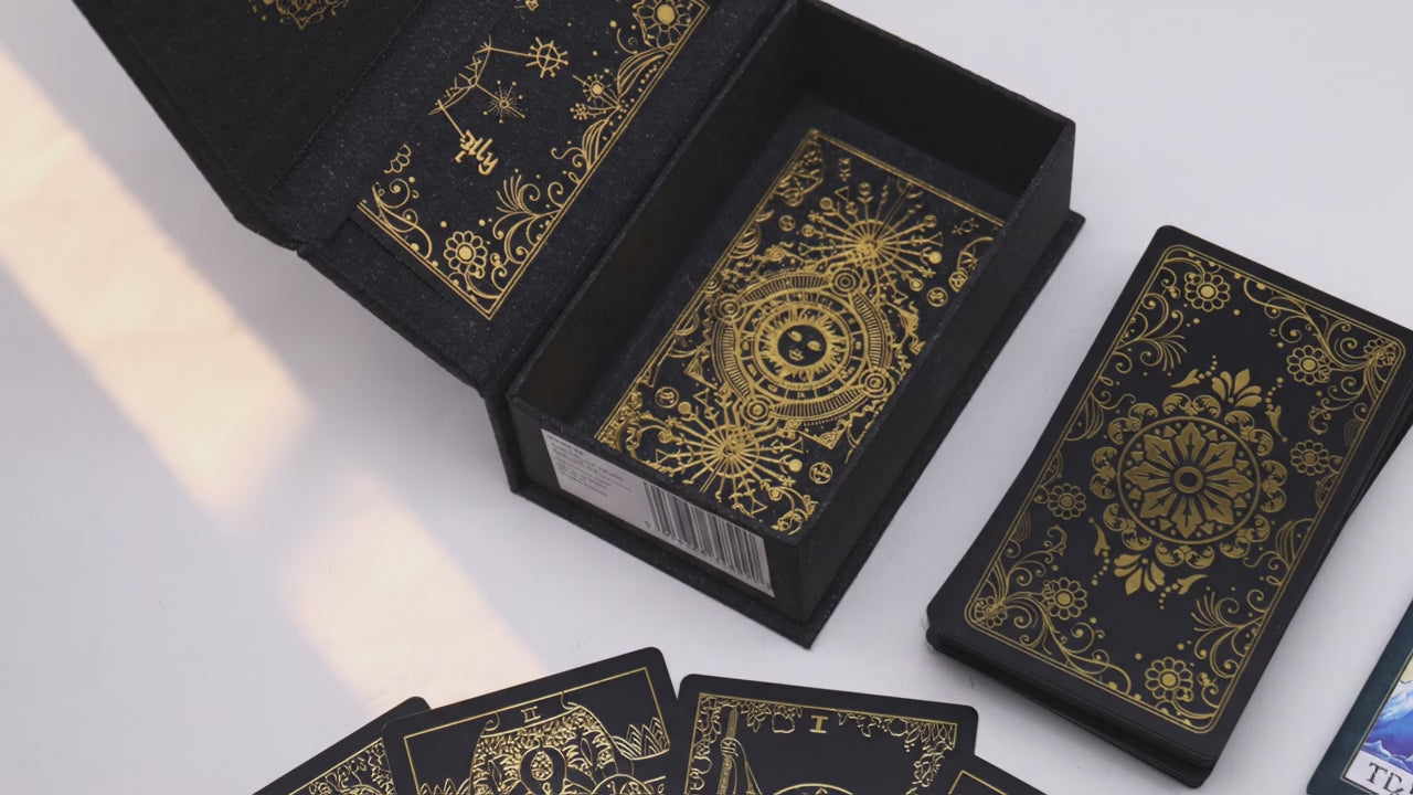 Gold foil tarot deck in its open gift box as warm window light moves across the table