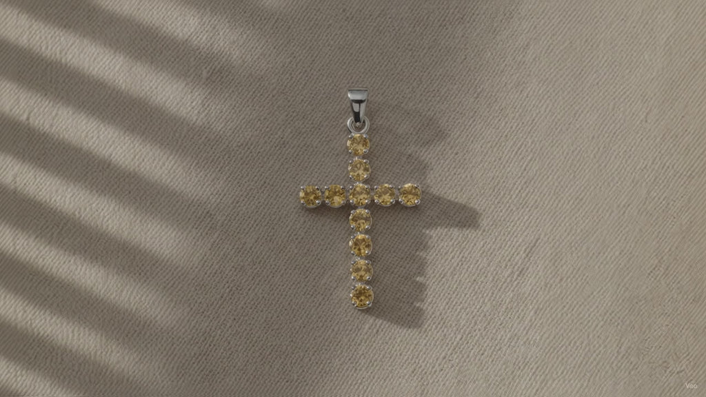 Silver-plated crucifix pendant set with golden citrine-coloured stones, on linen video