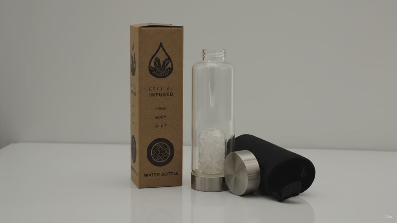 Clear quartz chips crystal water bottle with its box, lid and padded sleeve, soft light moving across the wall