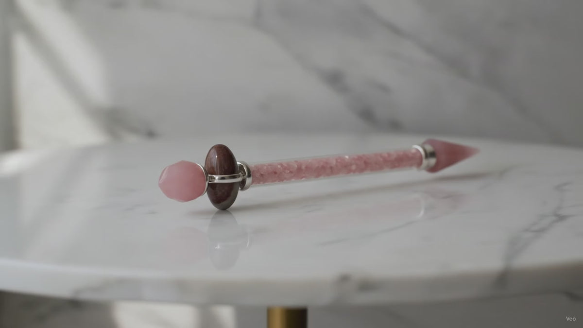 Rose quartz Shiva lingam wand on a marble table, slow product video