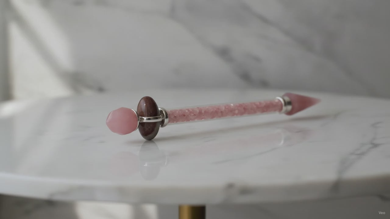 Rose quartz Shiva lingam wand on a marble table, slow product video