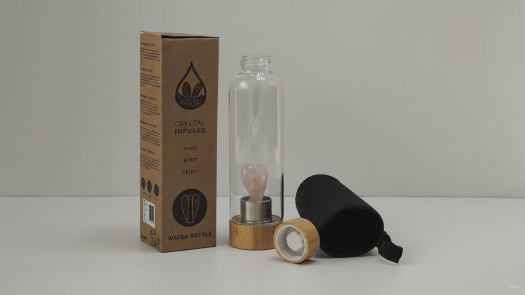 Rose quartz angel crystal water bottle with bamboo lid, box and padded sleeve, soft light moving across the wall