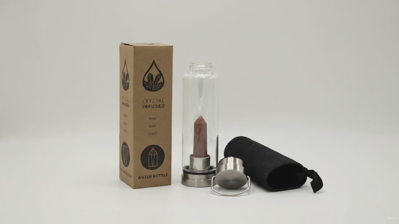 Red jasper crystal water bottle with its box, lid and padded sleeve, soft light moving across the wall