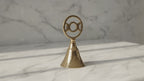Triple moon brass altar bell on a marble table, slow product video