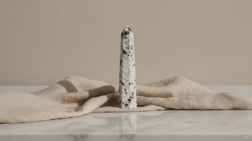 Rainbow moonstone crystal obelisk point on linen, slow zoom in