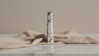 Rainbow moonstone crystal obelisk point on linen, slow zoom in
