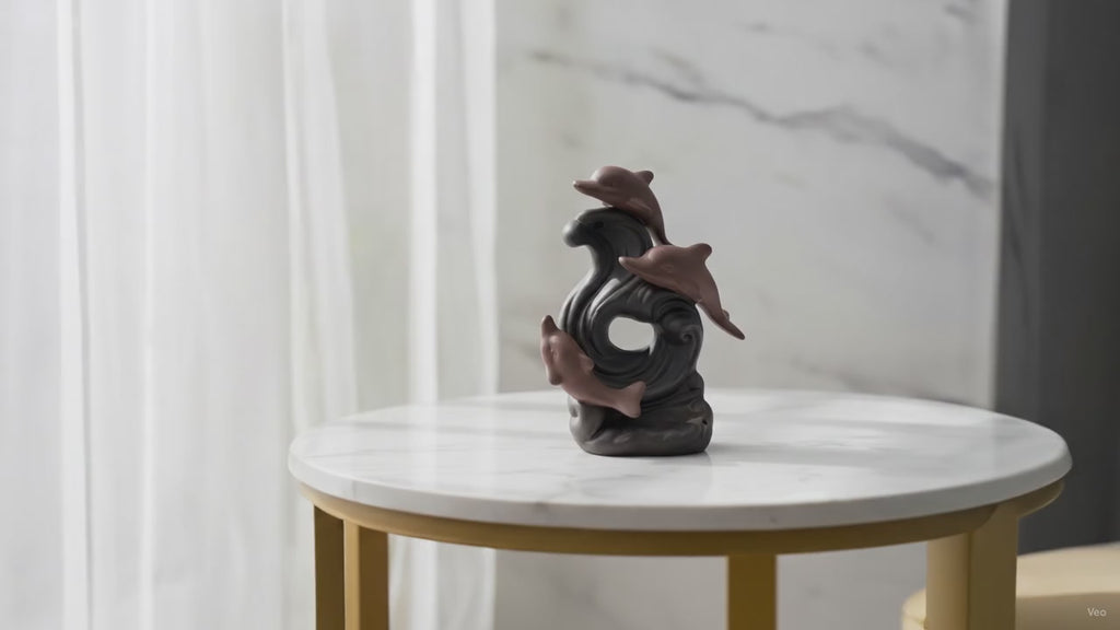 Dolphin wave backflow incense burner on a marble table, slow product video