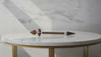 Tiger eye Shiva lingam wand on a marble table, slow product video