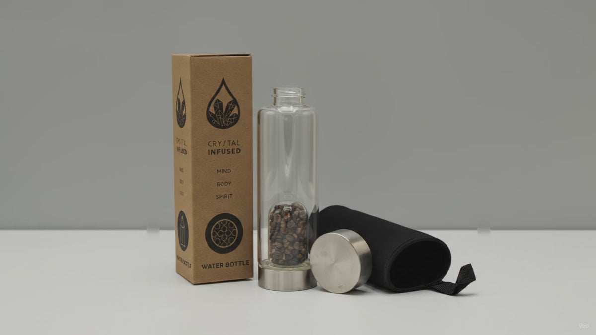 Tiger's eye chips crystal water bottle with its box, lid and padded sleeve, soft light moving across the wall