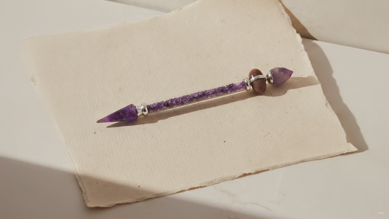 Amethyst shiva lingam wand with silver collars, lying on cotton-rag paper video