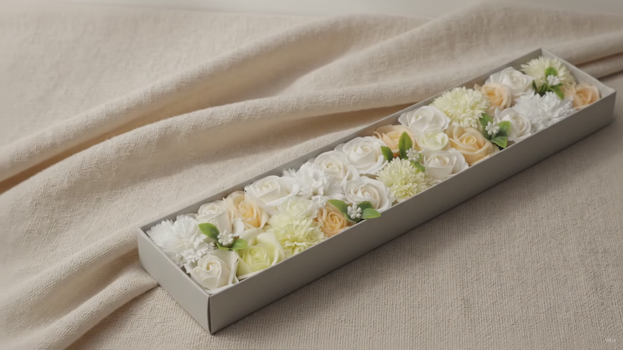 Long box of white and ivory soap roses lying open on cotton canvas video