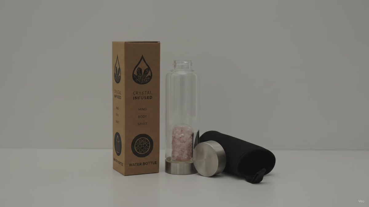 Rose quartz chips crystal water bottle with its box, lid and padded sleeve, soft light moving across the wall