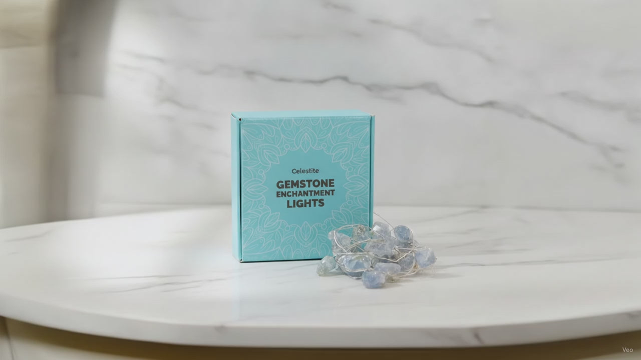 Celestite crystal fairy lights in their blue gift box on a marble table, sunlight moving across the wall