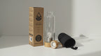 Clear quartz angel crystal water bottle with bamboo lid, box and padded sleeve, soft light moving across the wall