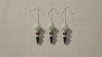 Three pendulums in green aventurine, tiger eye and black agate hanging side by side video