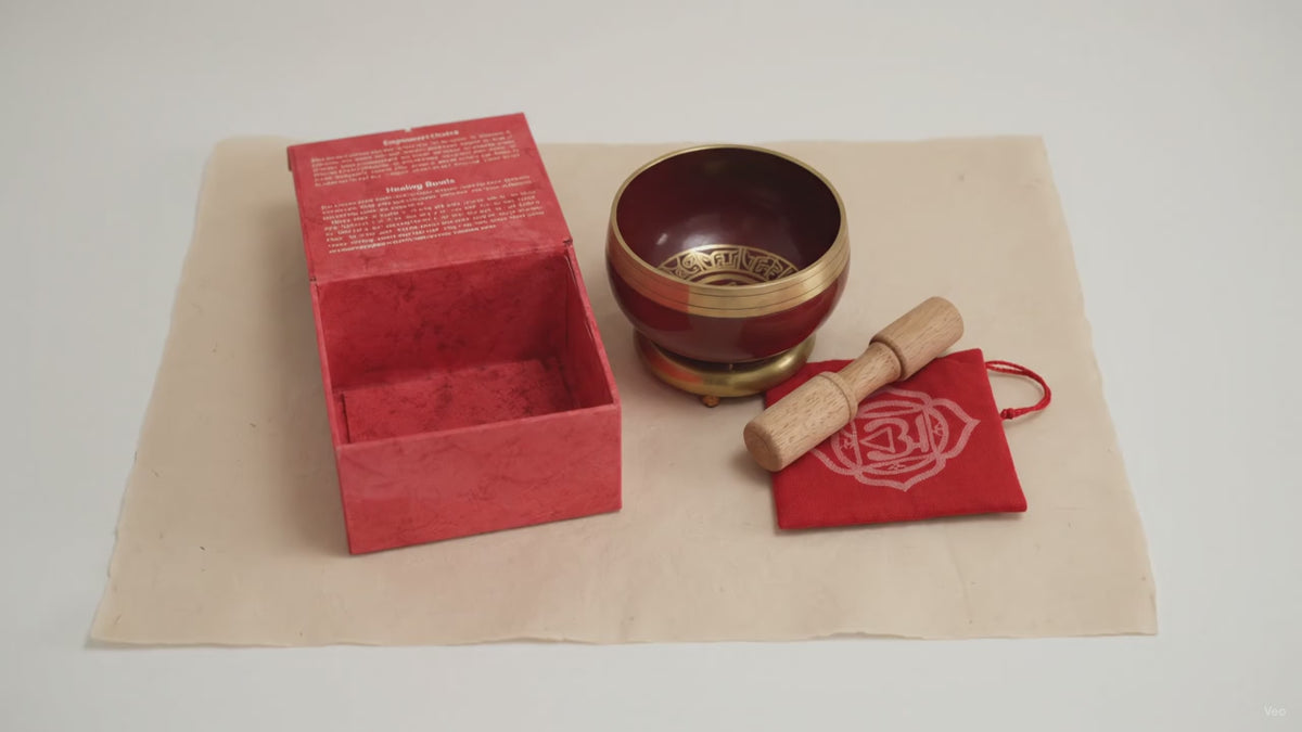 Red chakra singing bowl with its striker, cushion and box, on cotton-rag paper video