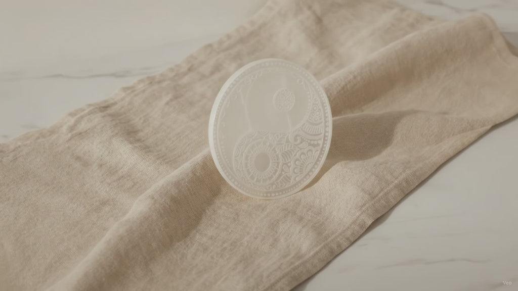 Large selenite charging plate with engraved feng shui design on natural linen