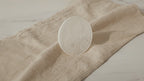 Large selenite charging plate with engraved feng shui design on natural linen