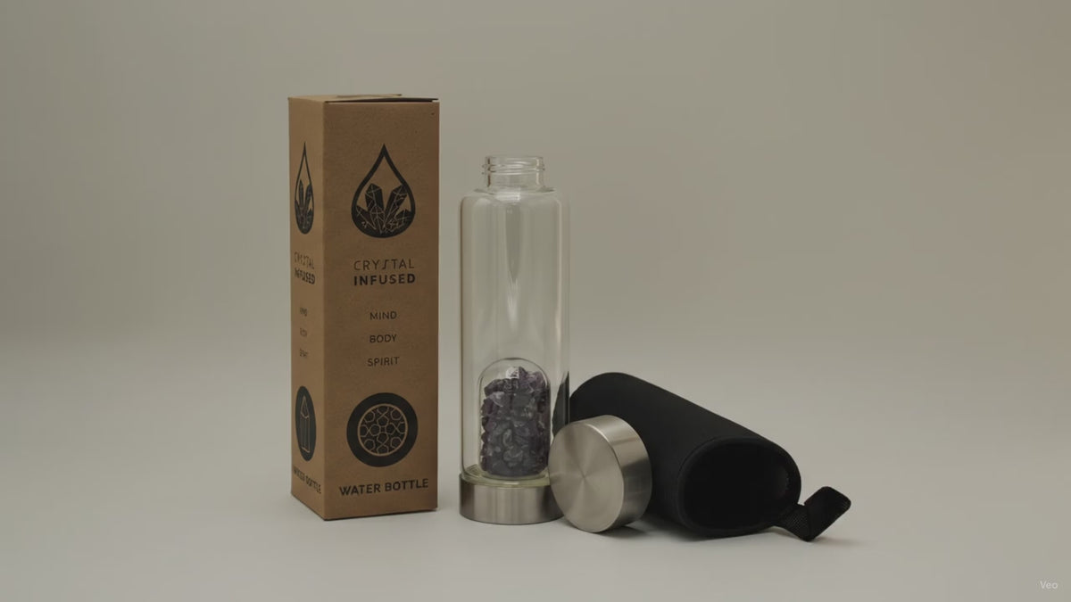 Amethyst chips crystal water bottle with its box, lid and padded sleeve, soft light moving across the wall