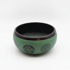 Earth powder singing bowl with mandala buddha on a clean white surface against a white wall