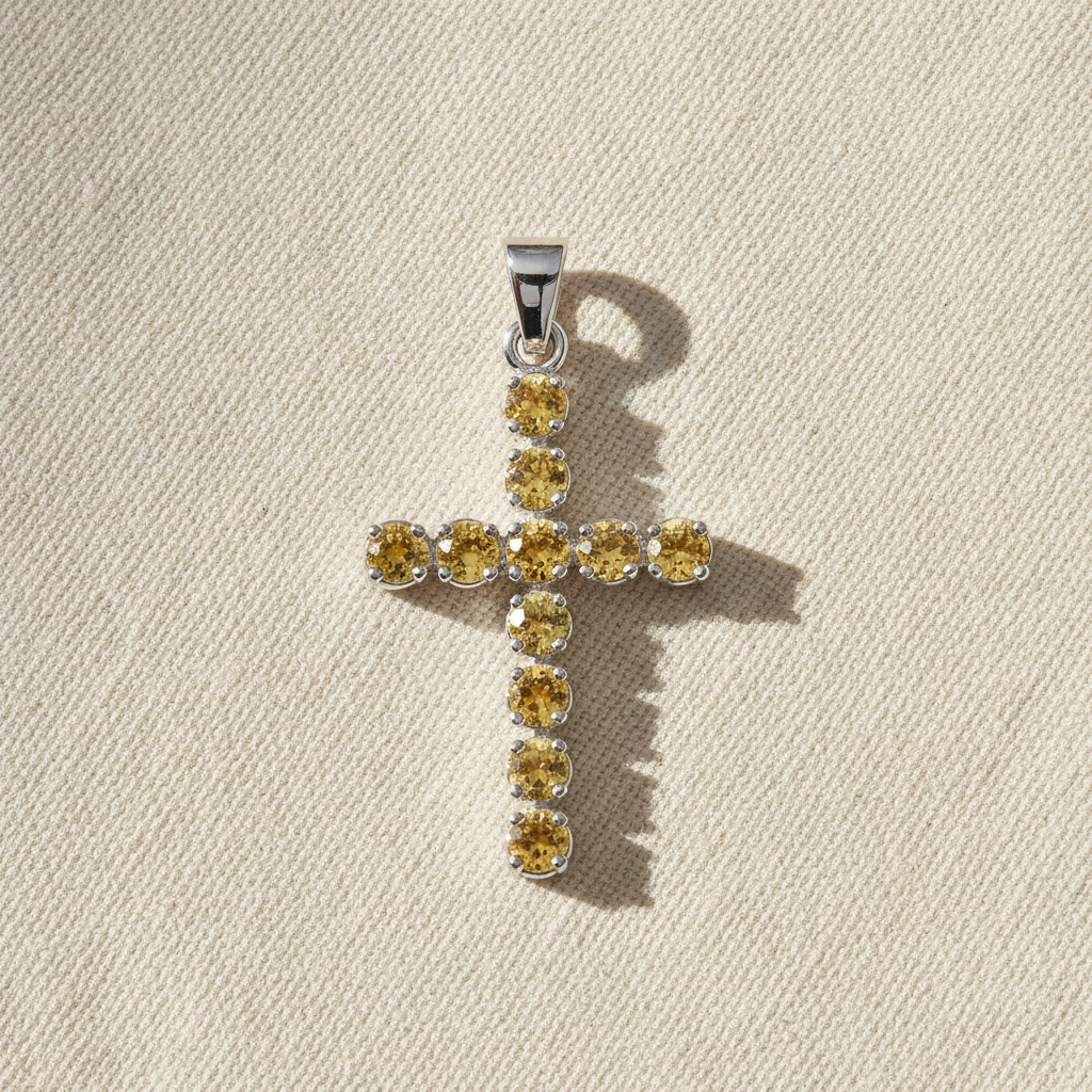 Silver-plated crucifix pendant set with golden citrine-coloured stones, on linen